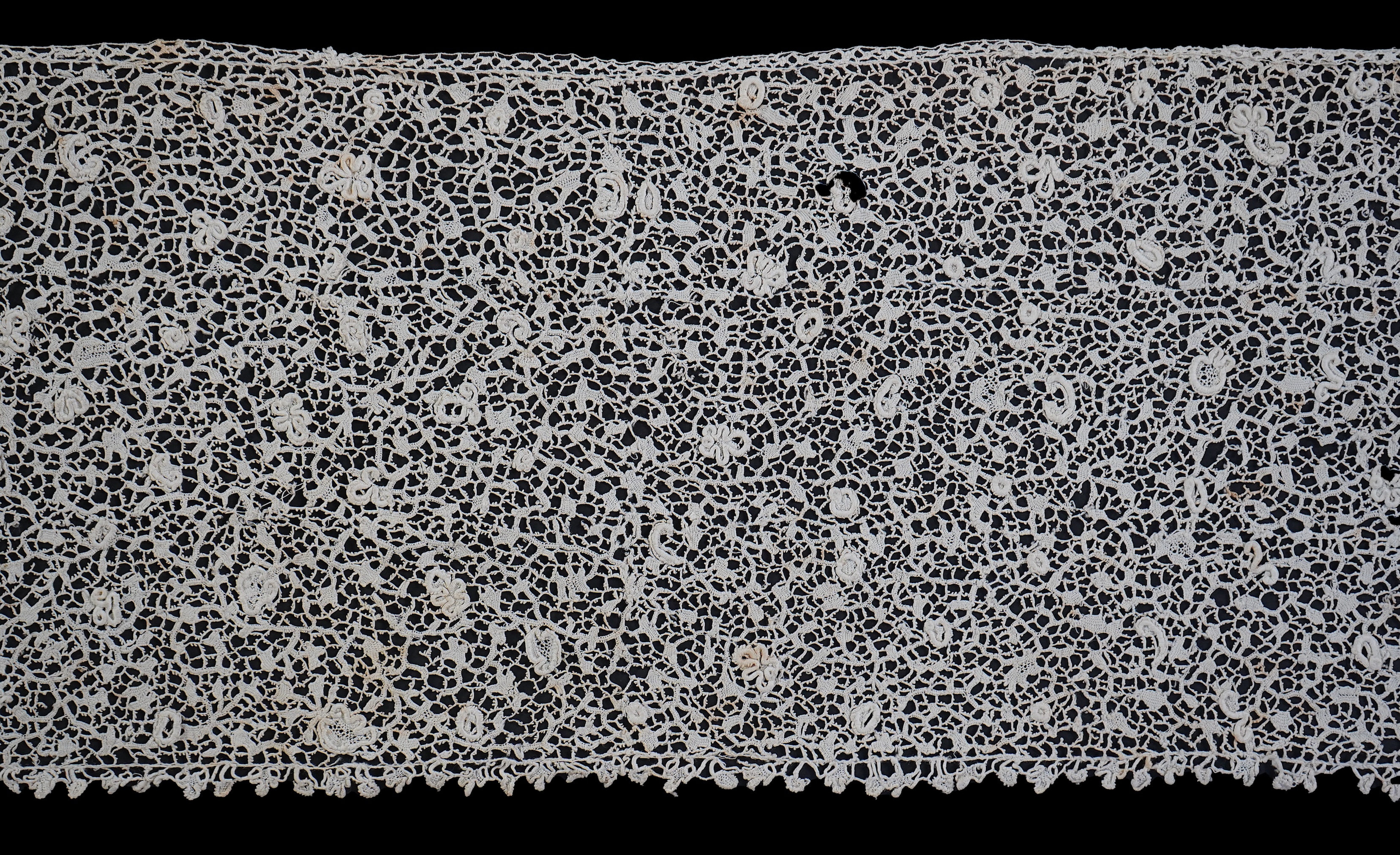 A late 17th century wide flounce of Point de France needle lace, together with a narrower flounce, both with raised elements of the design in the style of Point de Rose, but less so. This lace was very popular with the F